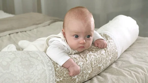 Happy baby rullande på sängen — Stockfoto