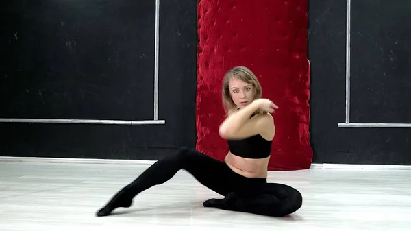 Eine junge sexy Tanzfrau, ein Poly-Dance-Tanz im Saal um die Stange — Stockfoto