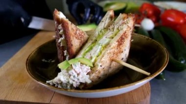 Adam öğle yemeği hazırlar, ızgara ekmek sandviç aperatif ahşap kesme tahtası, üst tarafı yeşil salata, hamburger ve yağ yavaş moyion sağlıklı alternatif ile hizmet vermektedir