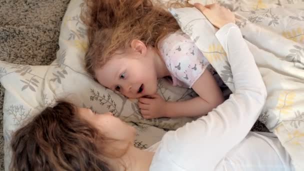 Happy woman and girls playing lying on the floor at home — Stock Video