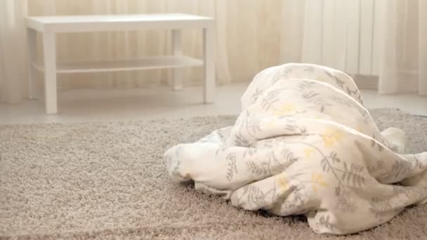 Mujer feliz y niñas jugando en fantasma tumbado en el suelo en casa — Vídeos de Stock