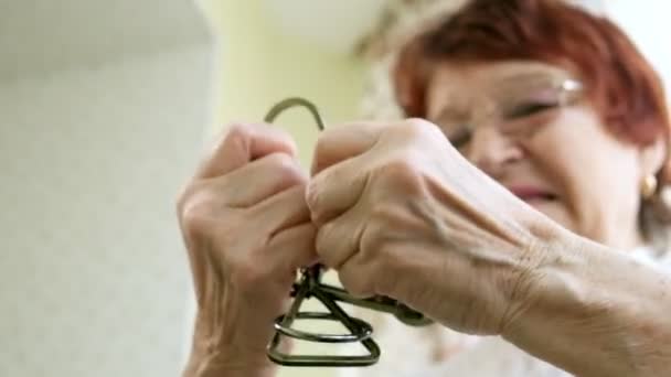 Eine alte Frau löst ein Metallpuzzle auf, trainiert Gehirnaktivität — Stockvideo