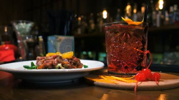 Koktejlové sklo na dřevěný stůl v baru. Zpomalený pohyb — Stock video