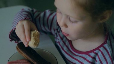 Bir kız evde masada yiyor