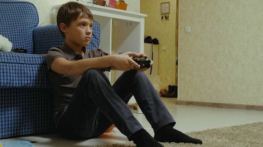 Bir video oyunu oynamak için bir Denetleyici kullanan çocuk