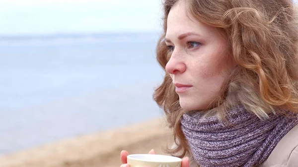 Termos sıcak çay veya kahve içme romantik genç kadın rahatlatıcı ile sahilde. Sakin ve rahat bir akşam. — Stok fotoğraf