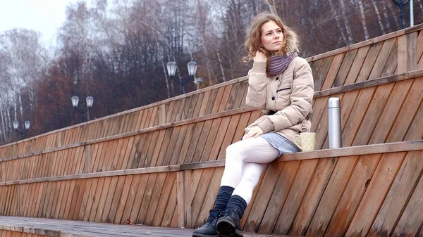 Romantique jeune femme se détendre sur la plage avec, boire du thé chaud ou du café de thermos. Soirée calme et confortable . — Photo