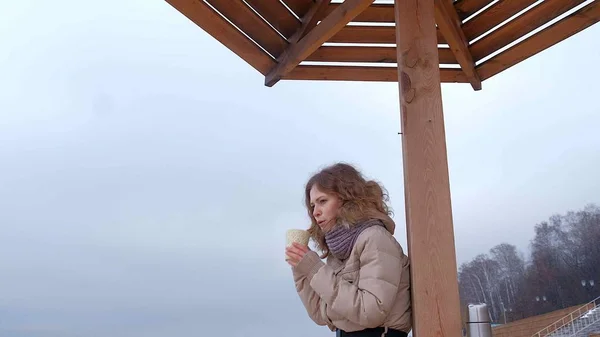 Mujer joven y romántica relajándose en la playa, tomando té caliente o café del termo. Calma y noche acogedora . — Foto de Stock