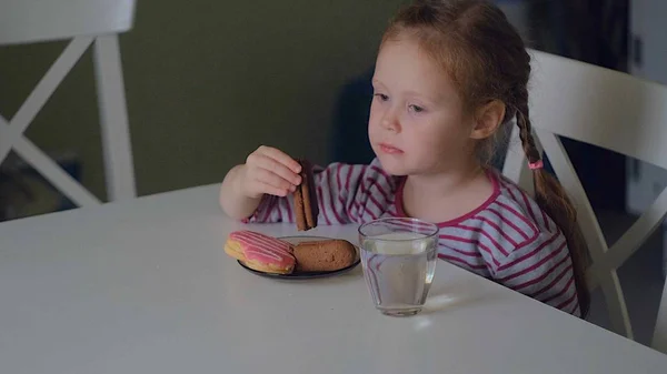 Een meisje eet aan de tafel thuis — Stockfoto