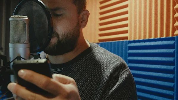 De creatieve muzikant man in studio werkt door te spelen, zingen en opnemen — Stockfoto