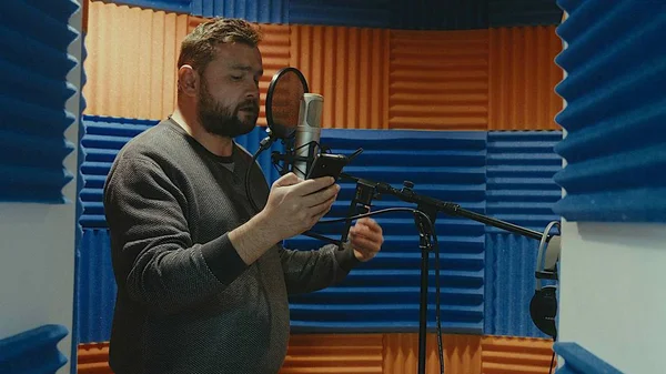 De creatieve muzikant man in studio werkt door te spelen, zingen en opnemen — Stockfoto