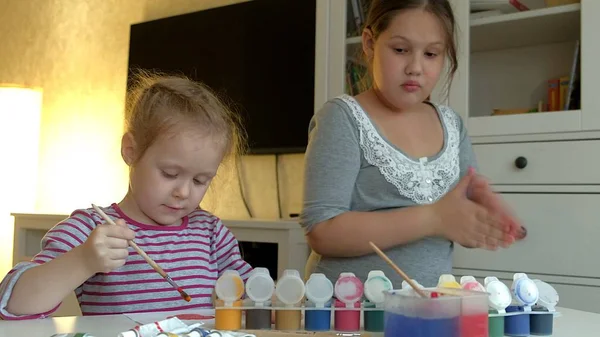 Niños pintan sobre papel con colores y pinceles — Foto de Stock