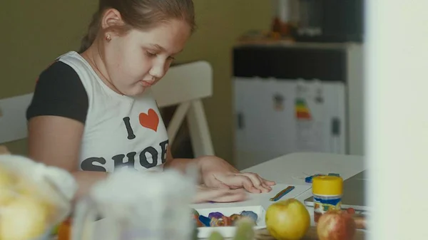 La niña esculpe figuras de plastilina en la mesa — Foto de Stock