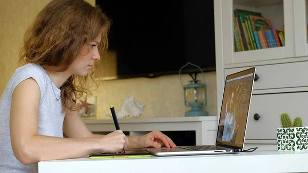 Kadın tasarımcı grafik tablet üzerinde çizer. Evde office içinde laptop ile çalışan kadın — Stok fotoğraf