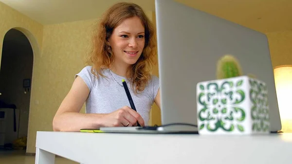 De ontwerper van de vrouw is geïnspireerd op een grafisch tablet gebruikt. Vrouw die werkt met laptop in office voor thuisgebruik — Stockfoto