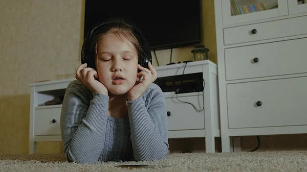 Συναισθηματική κοριτσάκι. Το μικρό κορίτσι με μακριά μαλλιά, Χορεύοντας με τα ακουστικά σε ένα σπίτι — Φωτογραφία Αρχείου