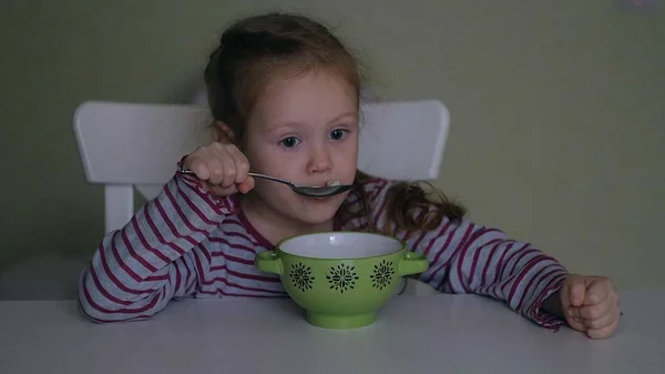 Dziewczyna zjada przy stole w domu — Zdjęcie stockowe