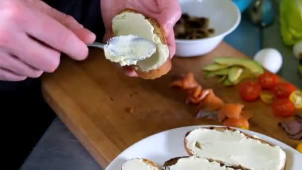 Hombre preparando bruschetta italiana con tomates al horno, albahaca y queso. Comida italiana cámara lenta — Vídeos de Stock