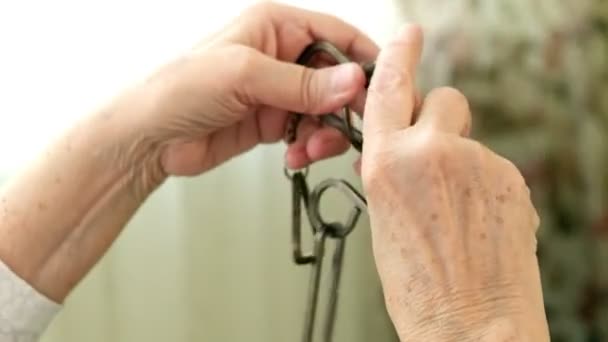 Стара жінка розпалює металеву головоломку, тренує мозкову активність — стокове відео