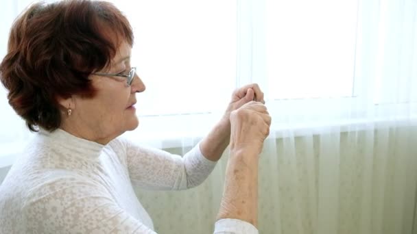 Стара жінка розпалює металеву головоломку, тренує мозкову активність — стокове відео