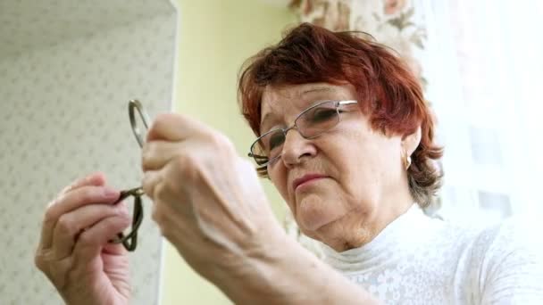 Una anciana desentraña un rompecabezas de metal, entrena la actividad cerebral — Vídeos de Stock
