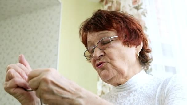 En gammal kvinna unravels en metall pussel, tränare hjärnan aktiviteten — Stockvideo