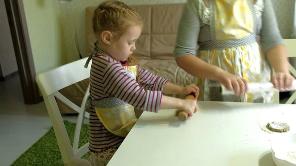 Zwei Kinder kneten gemeinsam den Teig für Plätzchen — Stockfoto