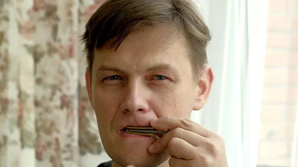 Portrait d'un homme jouant de la harpe. Le chaman barbu joue de l'harmonica drymba. Visage rapproché avec un instrument de musique Juifs Harpe . — Photo