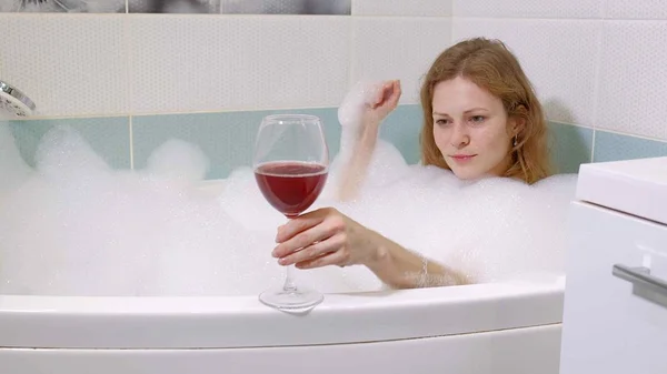 Woman blonde drinking wine while taking a bath. — Stock Photo, Image