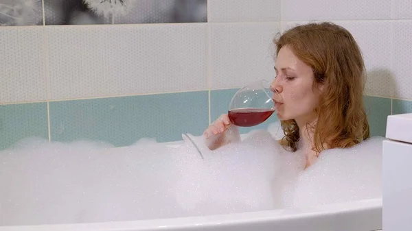 Vrouw blond wijn drinken terwijl het nemen van een bad. — Stockfoto