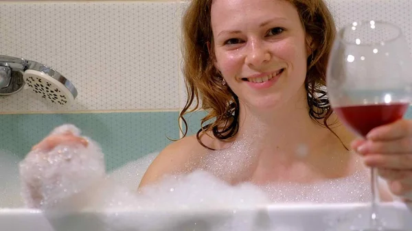 Woman blonde drinking wine while taking a bath. — Stock Photo, Image