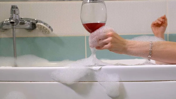 Woman blonde drinking wine while taking a bath. — Stock Photo, Image