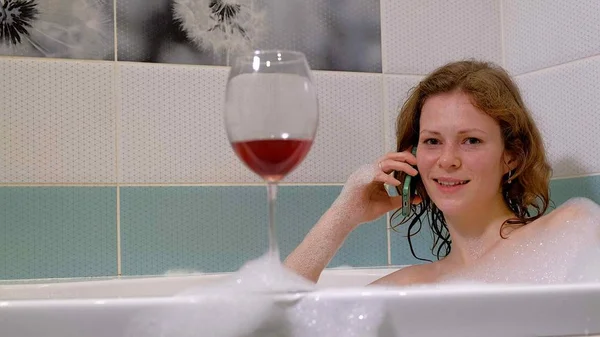 Woman blonde drinking wine while taking a bath. — Stock Photo, Image