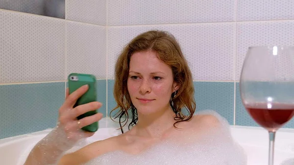 女人洗澡时喝葡萄酒的金发女郎. — 图库照片