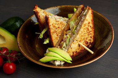 Tahta arka planda marul, jambon, peynir ve domatesli sağlıklı sandviç tostu.