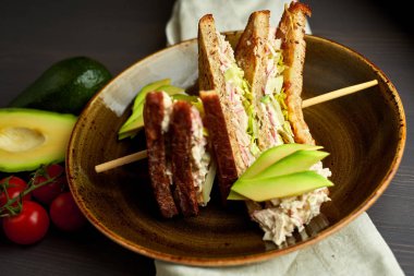 Tahta arka planda marul, jambon, peynir ve domatesli sağlıklı sandviç tostu.