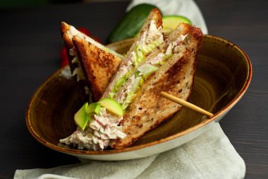 Tahta arka planda marul, jambon, peynir ve domatesli sağlıklı sandviç tostu.