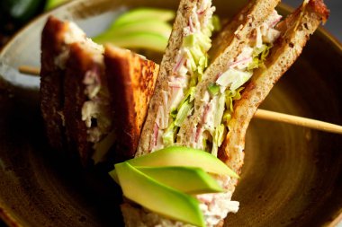 Tahta arka planda marul, jambon, peynir ve domatesli sağlıklı sandviç tostu.