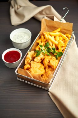 tavuk nuggets kızartması ve ahşap tahta üzerinde farklı sos ile,