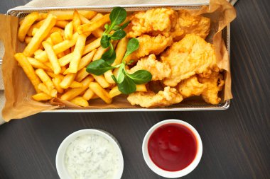 tavuk nuggets kızartması ve ahşap tahta üzerinde farklı sos ile,