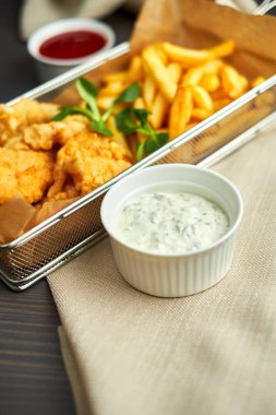 tavuk nuggets kızartması ve ahşap tahta üzerinde farklı sos ile,