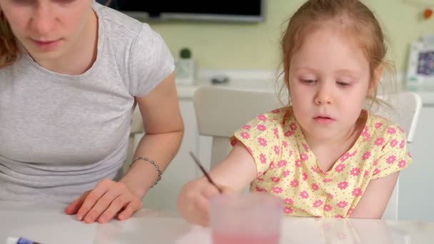 Família feliz mãe e criança pintura menina tintas em casa — Vídeo de Stock