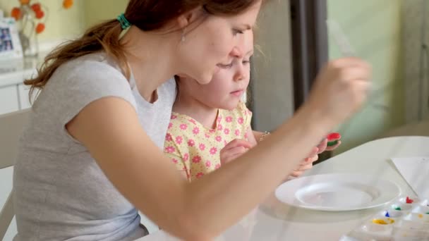 Famiglia felice, madre e bambina dipingono con le palme sui palmi delle mani — Video Stock