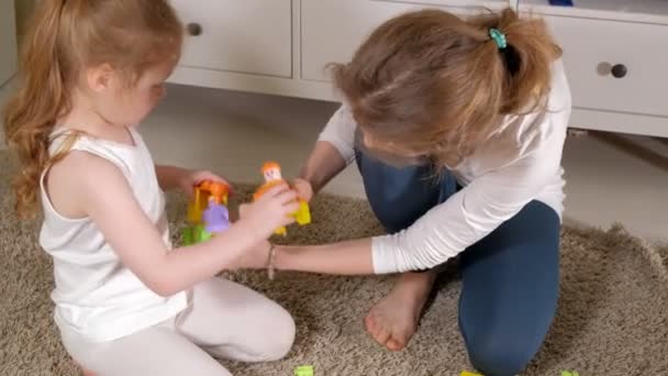 Feliz madre jugando con su hija en el diseñador — Vídeo de stock