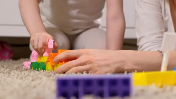 Счастливая мать играет с дочерью в дизайнере — стоковое видео