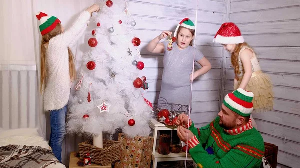 Famiglia intorno a un albero di Natale per decorarlo — Foto Stock