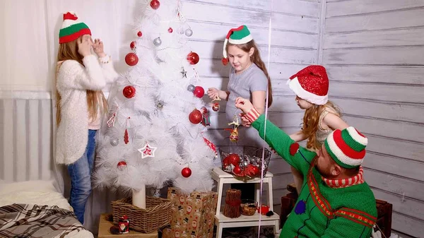 Familia alrededor de un árbol de Navidad para decorarlo —  Fotos de Stock