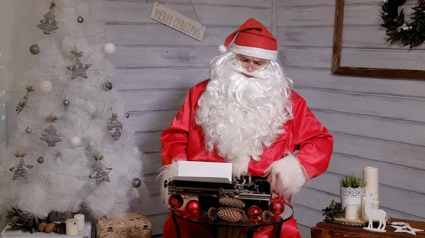 Papai Noel escrevendo resposta a uma carta em uma máquina de escrever — Fotografia de Stock