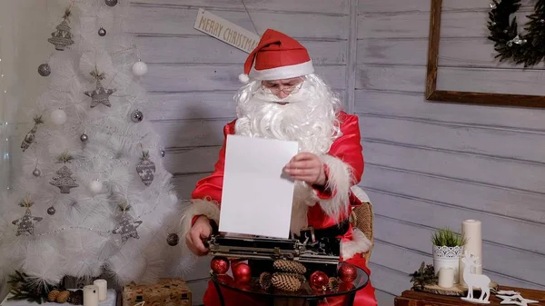 Santa Claus writing reply to a letter on a typewriter — Stock Photo, Image