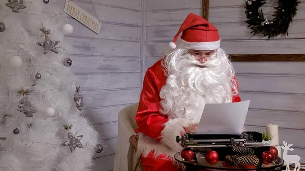 Papai Noel escrevendo resposta a uma carta em uma máquina de escrever — Fotografia de Stock